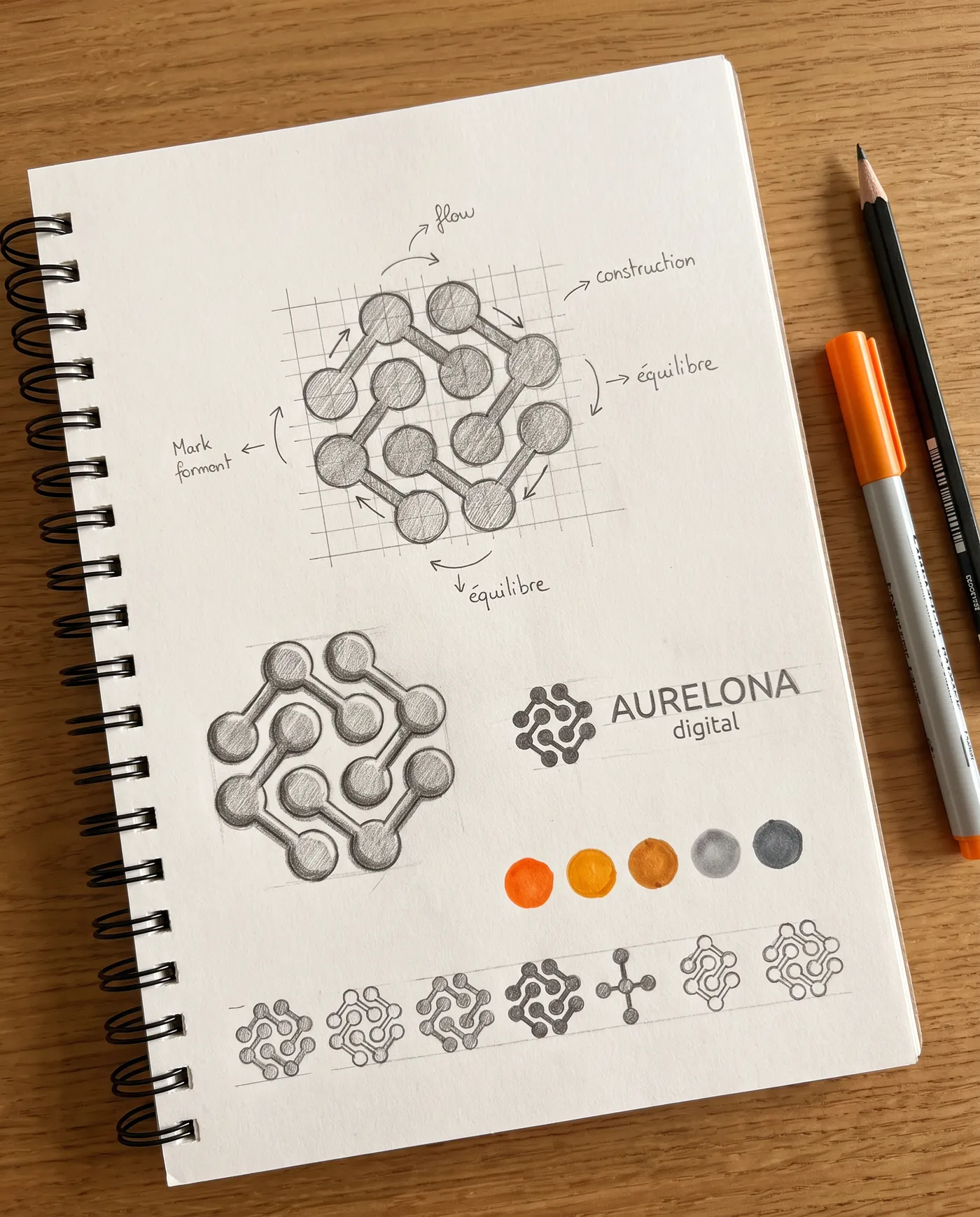 Une planche de croquis au crayon : le sigle d'Aurelona en étude de construction sur une grille, sa version aboutie, le lettrage, et une rangée de pastilles de couleur
